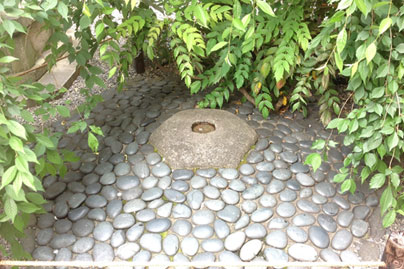 町の真ん中を示すという六角堂の「へそ石」。