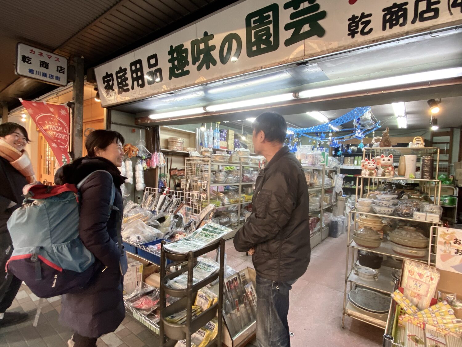 店に立つ乾代表理事(右)