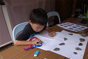 鴨川で見つけた石の大きさを計る子どもたち